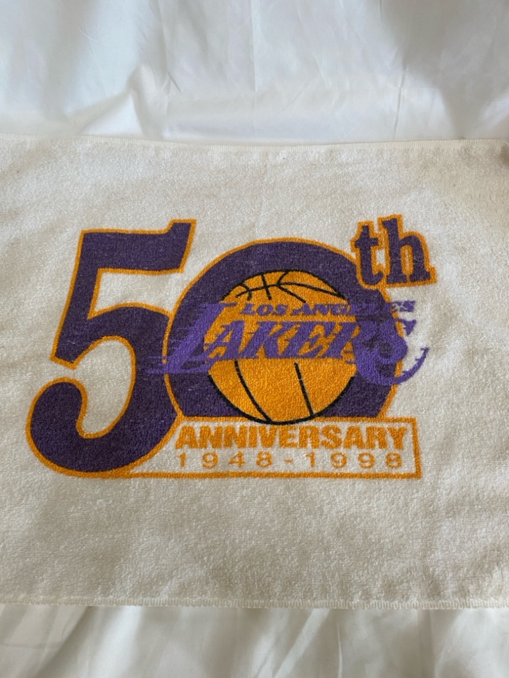 Los Angeles Lakers 50th anniversary towel with team's commemorative logo.